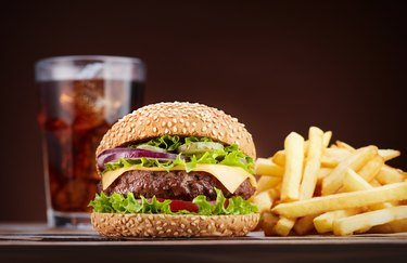 fast food cheeseburger with cola and french fries