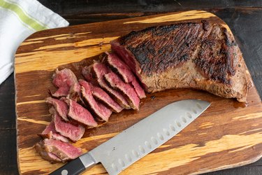 Rare slices of tri-tip steak on a bamboo cutting board