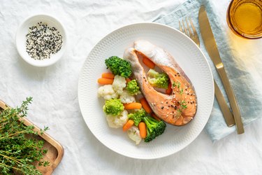 top view of a plate of steamed salmon and vegetables on a white plate