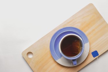 Top view of a blue cup of khas khas tea drink on a wooden cutting board to show khas khas side effects