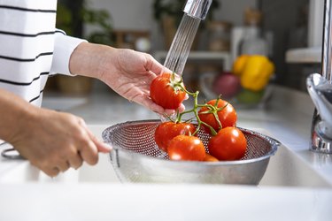 Woman washing vegetables on kitchen counter