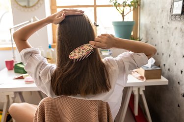 back view of a person combing their long brown hair