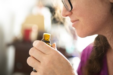 Woman Smells Aromatherapy Essential Oil, as part of smell training to recover from COVID-19 loss of smell