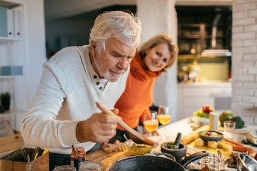 Older couple preparing meal in kitchen with nutrients for longevity