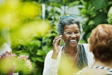 Laughing woman hanging out with friends during backyard dinner party