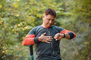 Senior Hiker Measuring a sudden drop in heart rate With Smartwatch