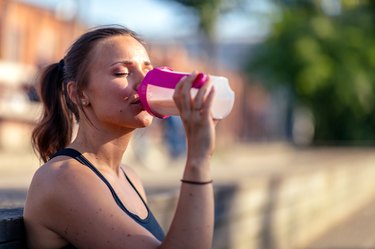 Woman drinking protein shake to represent a myth about protein and weight loss