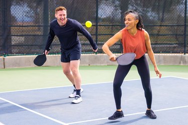 Two pickleball players playing doubles with the best pickleball paddles.