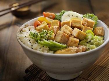 Tyrosine-rich grilled tofu with vegetables and white rice in a white bowl on a wooden board.