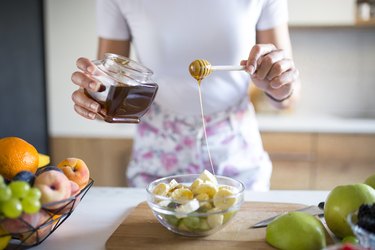 Preparing a fruit bowl for breakfast with glucose-rich foods like honey and fruit