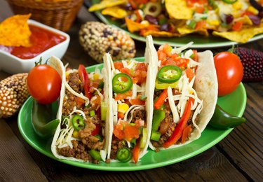 Beef tacos on green plate with toppings