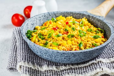 Tofu scramble with vegetables in a pan. Vegan Alternative Omelet.