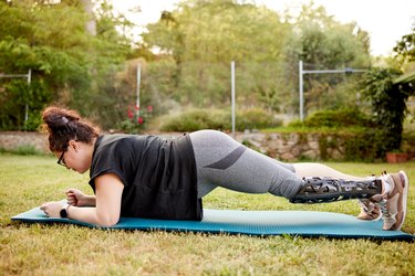 Person doing a plank exercise outside to demonstrate a beginner full-body workout.