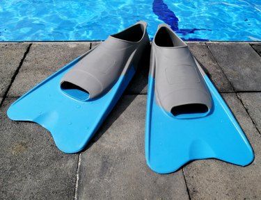 a pair of blue and gray swim fins at poolside