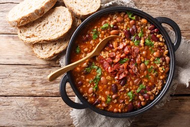 Delicious cowboy stew of beans with ground beef, bacon in a spicy sauce closeup in a bowl. horizontal top view