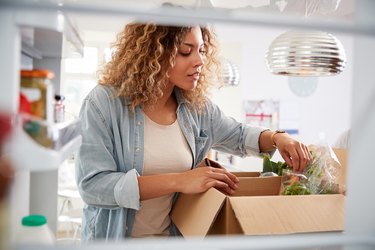 认为从冰箱里面女人解包在线家庭食品交付最通用的食品