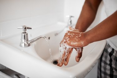 A man washing his hands in the bathroom at home