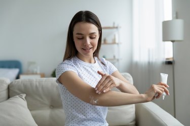 woman applying a natural pain-relief cream to her elbow