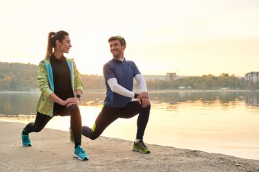 Young man and woman stretching before running