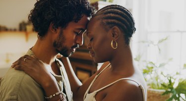 Shot of a young couple standing together and sharing an intimate moment at home