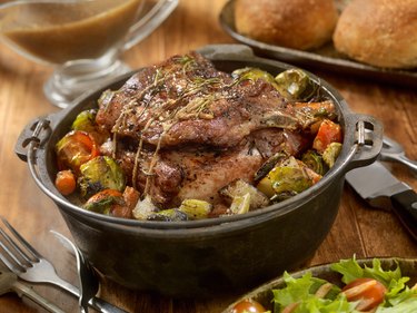 Slow cooker Prime rib roast dinner with vegetables on wooden table