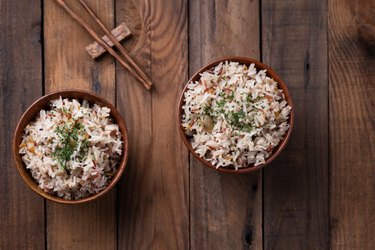 fried rice with vegetable and grains in bowl on wooden table