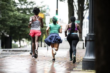 Three people wearing workout clothes going for a run outside to demonstrate how many calories are burned on a 15-minute run.