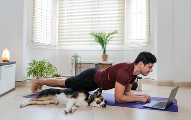 Adult doing forearm plank to relieve back pain in living room.