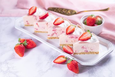 Keto cheesecake bites with fresh strawberries on a marble background