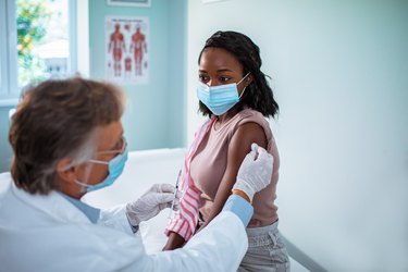Young woman getting flu shot at doctor's office