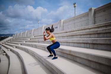 一个女人一边听音乐一边在外面的楼梯上锻炼