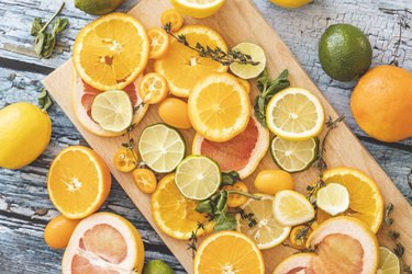 Slices of foods high in vitamin c for skin health including sliced oranges, lemons, grapefruits, and limes on a cutting board