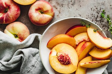 Slices of ripe peaches in a bowl.