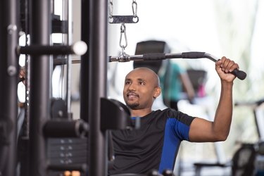 Man using lat pulldown machine at the gym during weightlifting workout