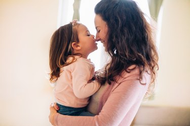 A  smiling mother holding her toddler