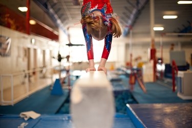 Young Gymnast Doing Handstand on Balance Beam