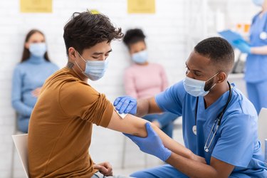 man getting COVID vaccine in his right arm