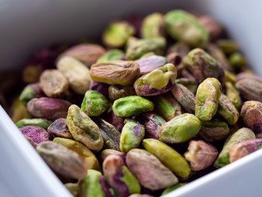Close-up of Shelled Raw Pistachios in Square White Bowl
