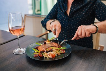Man eating salmon and drinking wine, two anti-inflammatory foods