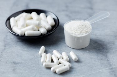 White MSM (Sulfur) capsules on a gray stone background