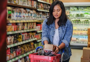 shopper reading food label for foods with dextrose at the supermarket