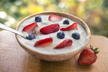 a bowl of yogurt with strawberries and blueberries, as an example of foods to eat on the Dr. Now diet