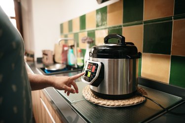 a person in a kitchen Cooking with an instant pot