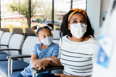 a mother and daughter wearing masks at the dentist office