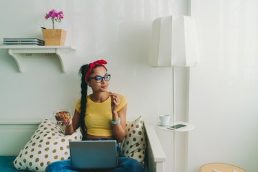 a woman eating almonds while working from home