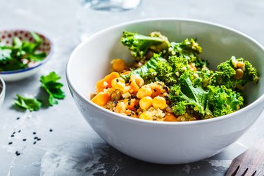 Vegan stew with chickpeas, sweet potato and kale in white bowl.