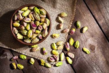 CoQ10-rich pistachios in bowl on wooden table