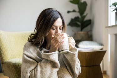 A woman at home drinking tea as a natural remedy for sore throat