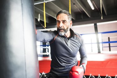 A man with prostate cancer exercising at the gym by boxing