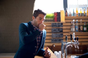 A man burping while standing at a bar